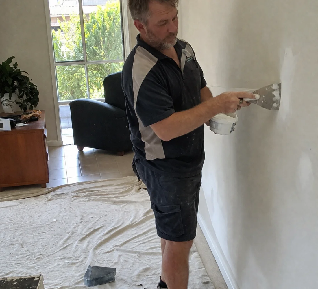 Canberra handyman patching a plasterboard wall inside a home